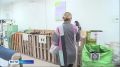 Велосипед посреди комнаты, груды пластиковых бутылок, картонок и джинсовый диван